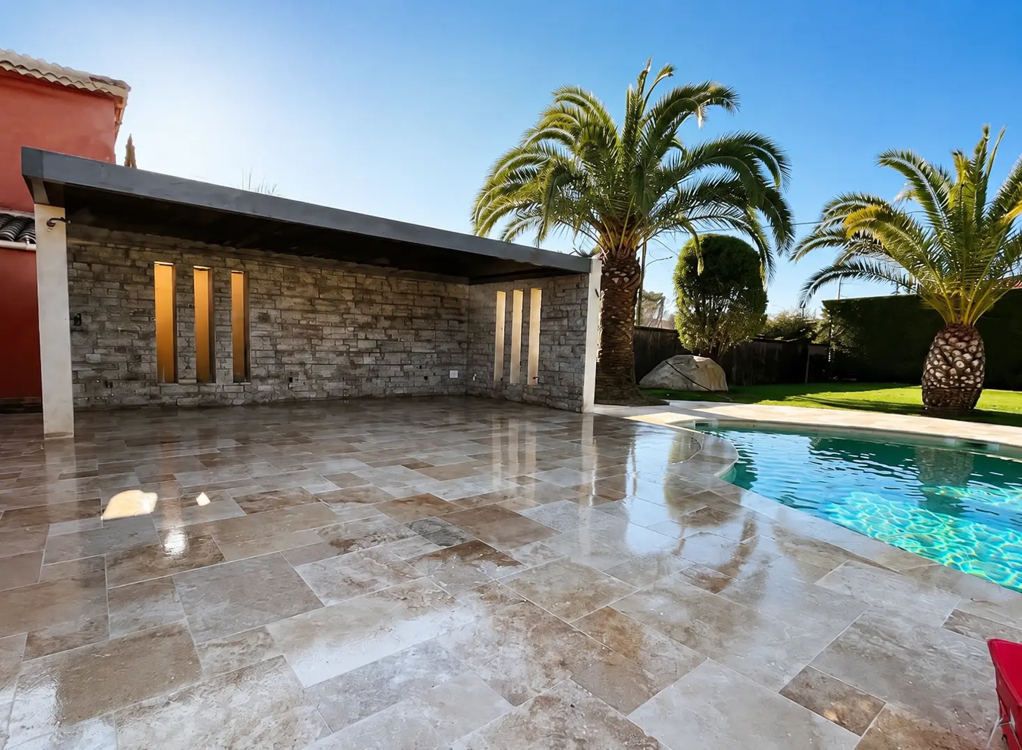 Terrasse en pierre rénovée autour d’une piscine
